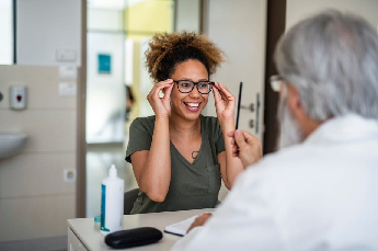 Woman trying on eyeglasses at an exam